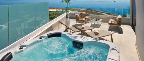 A hot tub on a balcony with a view of the sea.