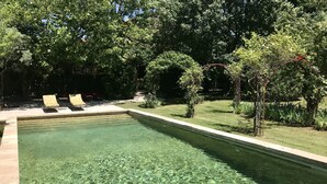 A rectangular swimming pool with clear water, surrounded by a grassy area and trees. - Authentic farmhouse with large swimming pool, near Aix en Provence (Pourcieux)