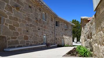 Un edificio de piedra con techo plano, una ventana pequeña y una puerta.