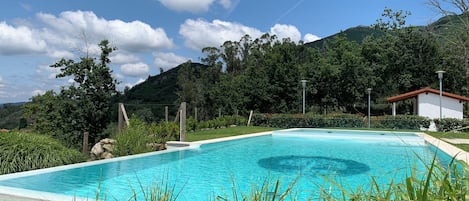 Una piscina al aire libre de temporada, sillones reclinables de piscina