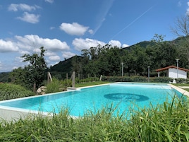 Una piscina al aire libre de temporada, sillones reclinables de piscina