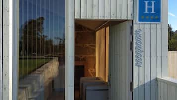 A modern hotel with a wooden exterior, a glass door entrance, and a sign indicating a hotel with a rating of 4 stars.