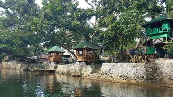 A riverside area with wooden structures and stone walls.