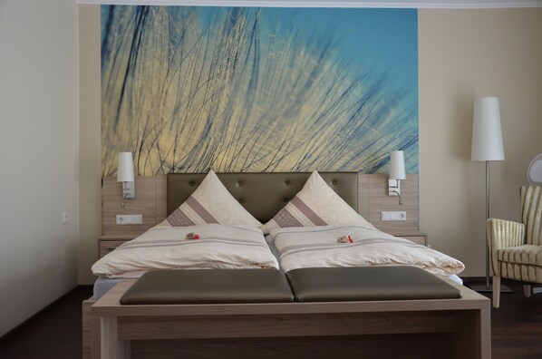 A double bed with a wooden headboard, two bedside tables, and a large abstract painting on the wall. - Hotel Dreyer (Bad Rothenfelde)