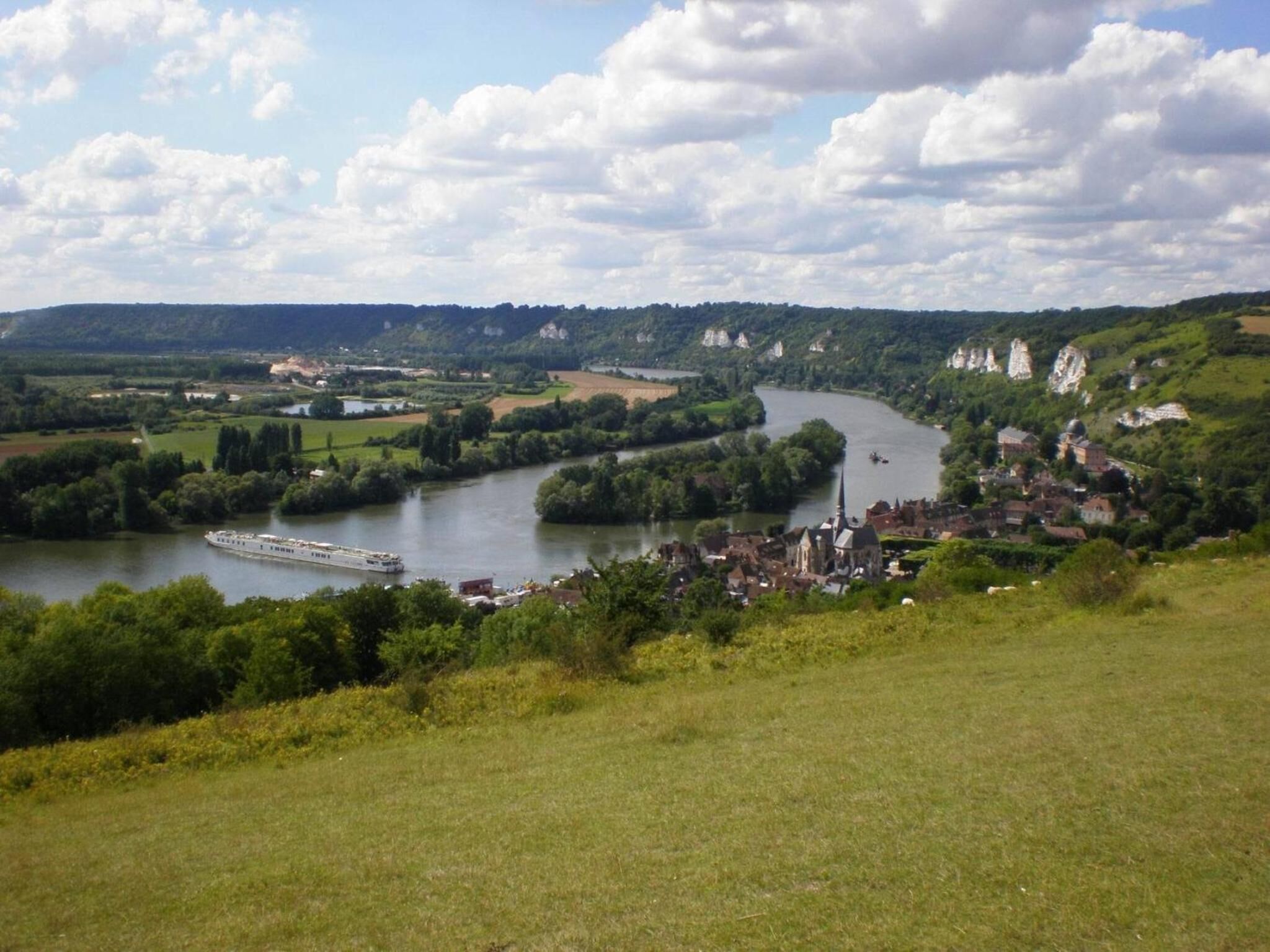 A river flowing through a town with buildings and greenery.