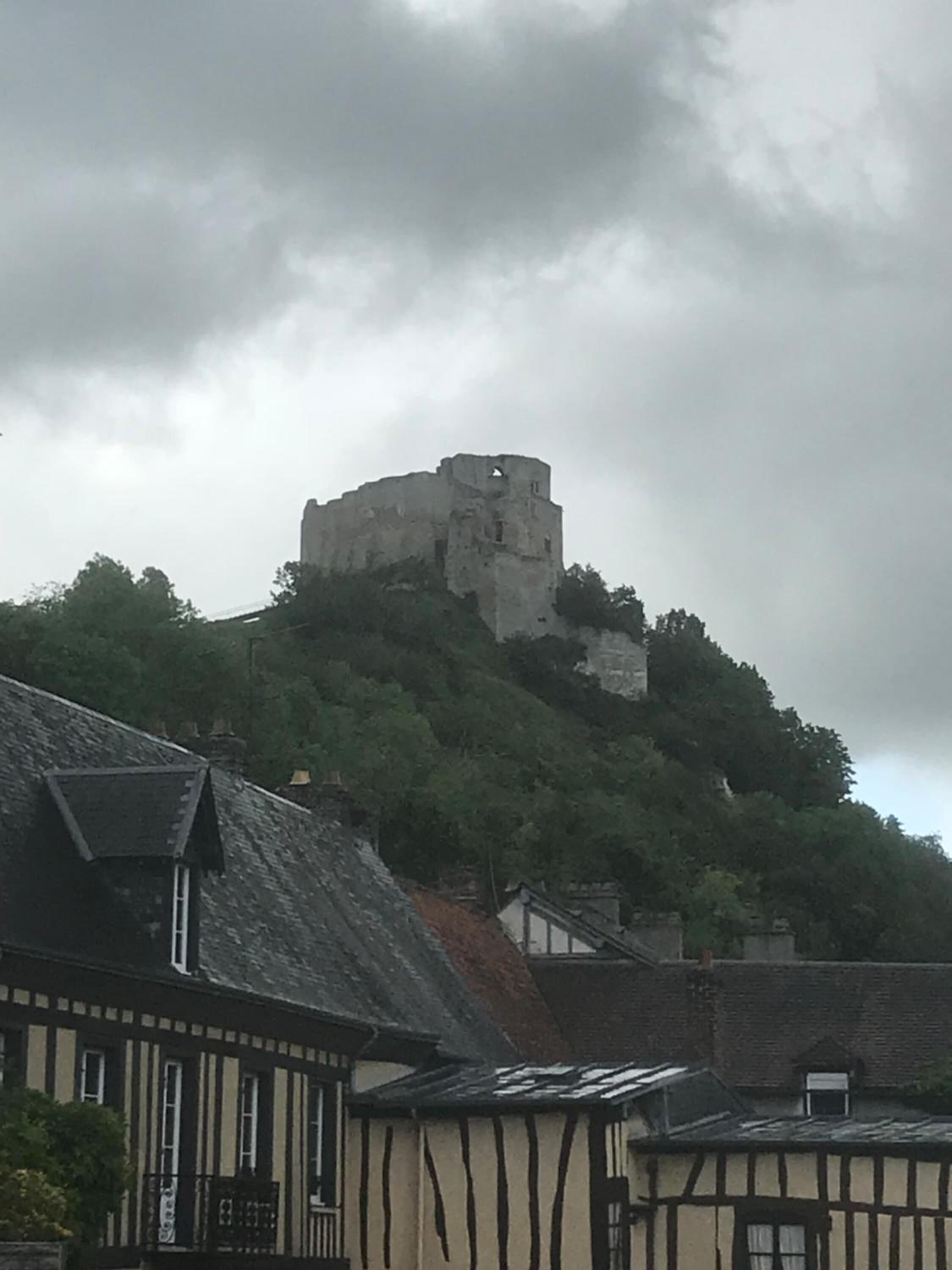 Un castello medievale su una collina, con edifici tradizionali in primo piano.