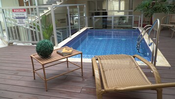 Una piscina techada, sillones reclinables de piscina