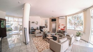 Un salón amplio con un ventanal grande, una chimenea y una cocina moderna al fondo.