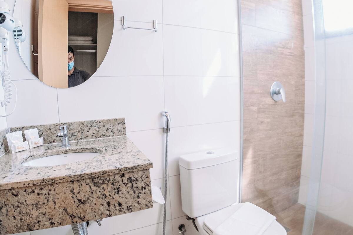 Une salle de bain moderne avec un lavabo en granit, des toilettes et une douche à parois de verre.