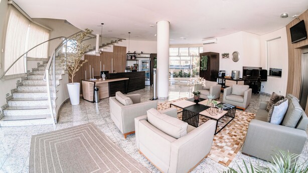 Amplia sala de estar con una escalera, una cocina y un área de descanso con sofás y una mesa de centro.