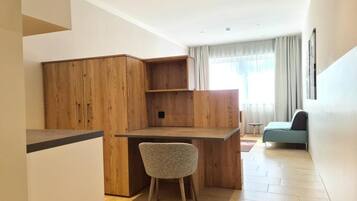 A compact living space with a kitchenette, a dining area, and a seating area.