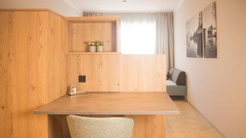 Eine moderne Küche mit Holdekor, einer Arbeitsplatte und einem Stuhl. Ein Fenster mit Vorhängen und ein Bild an der Wand sind zu sehen.