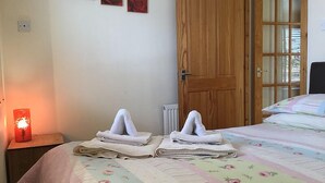 Un dormitorio con cama, una puerta de madera y un radiador.