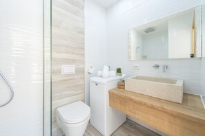 Een bad/douchecombinatie, een haardroger, handdoeken, shampoo