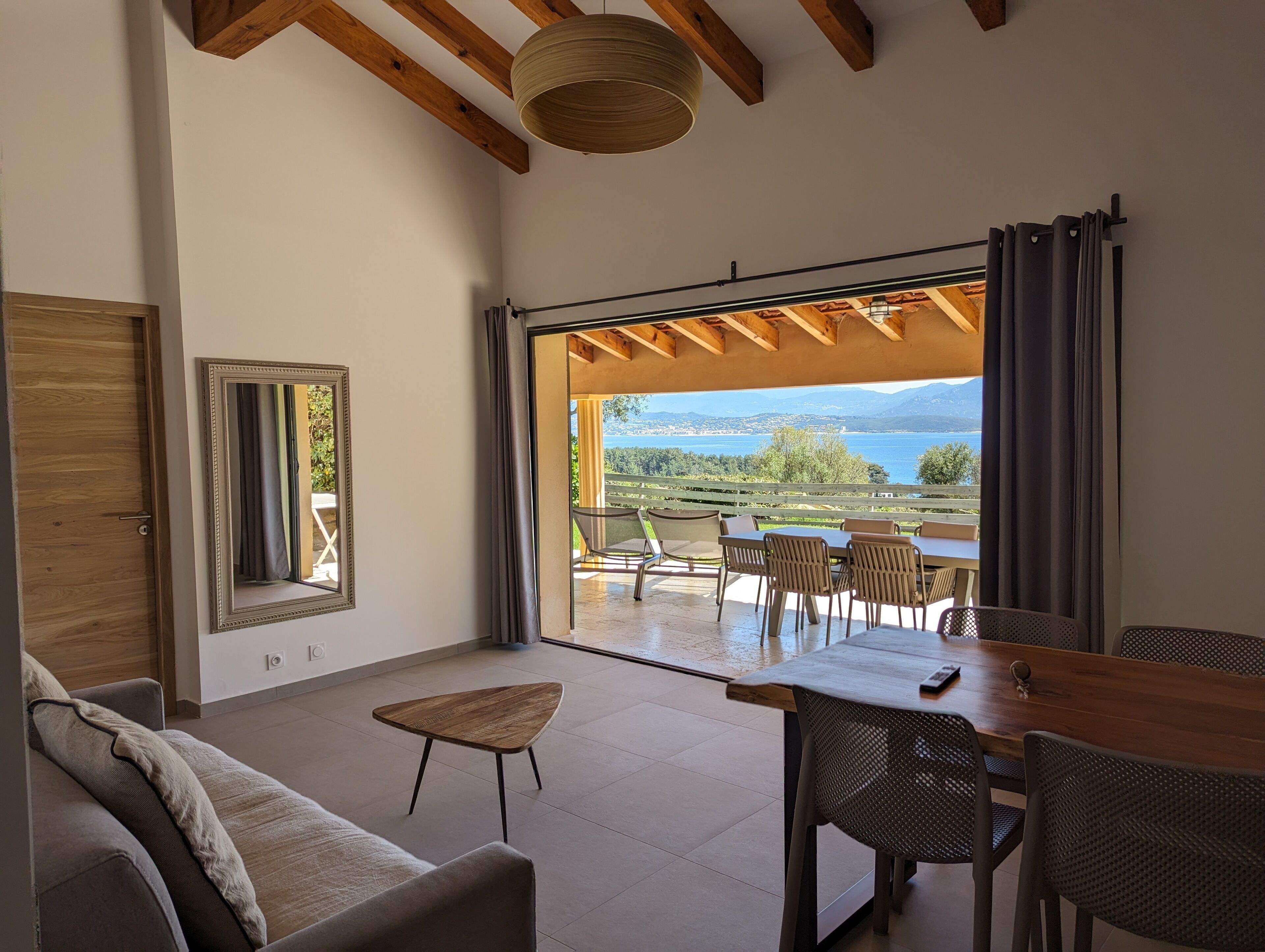 A modern living room with a large sliding glass door leading to an outdoor patio.