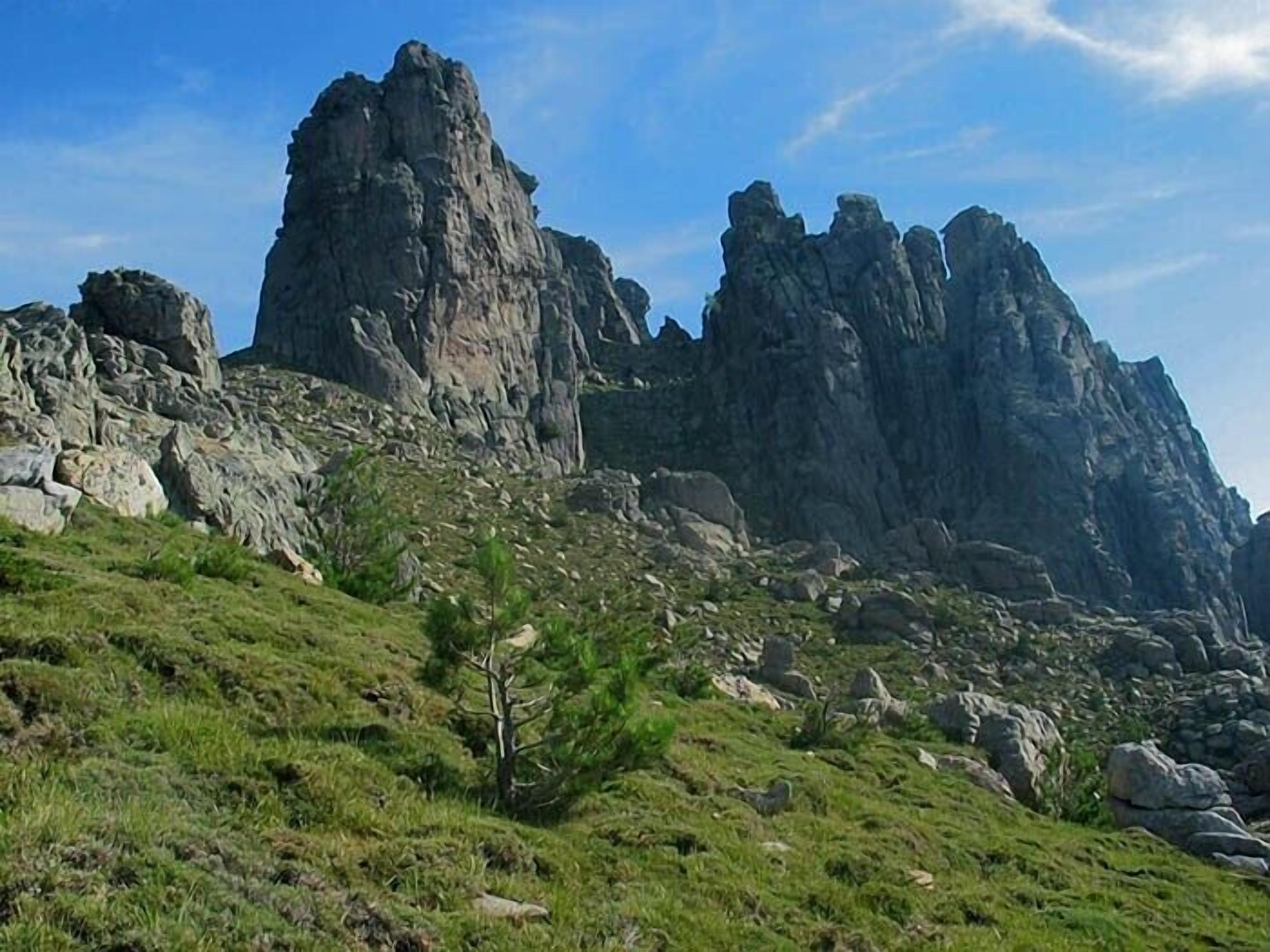 A mountainous landscape with rocky outcrops and sparse vegetation.