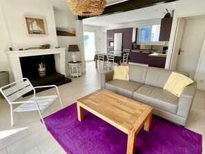 Ein modernes Wohnzimmer mit Kamin, einer Couch, einem Couchtisch und einem Essbereich.