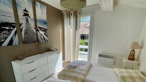 A bedroom with two beds, a white dresser, a lamp, and a painting of a lighthouse. - Perfect holiday home in Hourtin-Plage with wifi and very close to the beach (Hourtin)