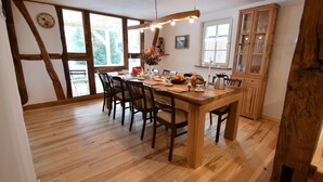 Un comedor con una mesa de madera, sillas y un armario.