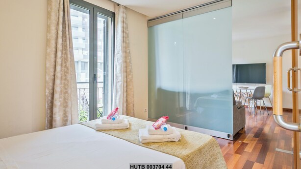A hotel room with a bed, a bathroom, and a view of the city. - Alcam Anglesola (Barcelona)