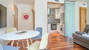 A modern living room with a dining area, a sofa, and a kitchen with appliances. - Alcam Anglesola (Barcelona)