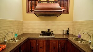 Una cocina con armarios de madera, estufa integrada y una ventana sobre el fregadero.