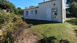 A small, single-story white building with a tiled roof, a door, and a window. - Spacious villa near beach, 5 people, private garden (La Faute-sur-Mer)