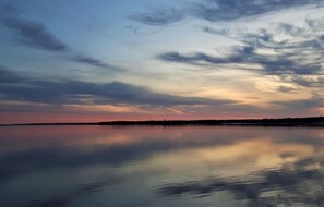A calm lake with a sunset reflection, clear skies, and a distant shoreline. - Honeycomb Cottage - bright, airy and spacious sanctuary with water view! (Donaldston)