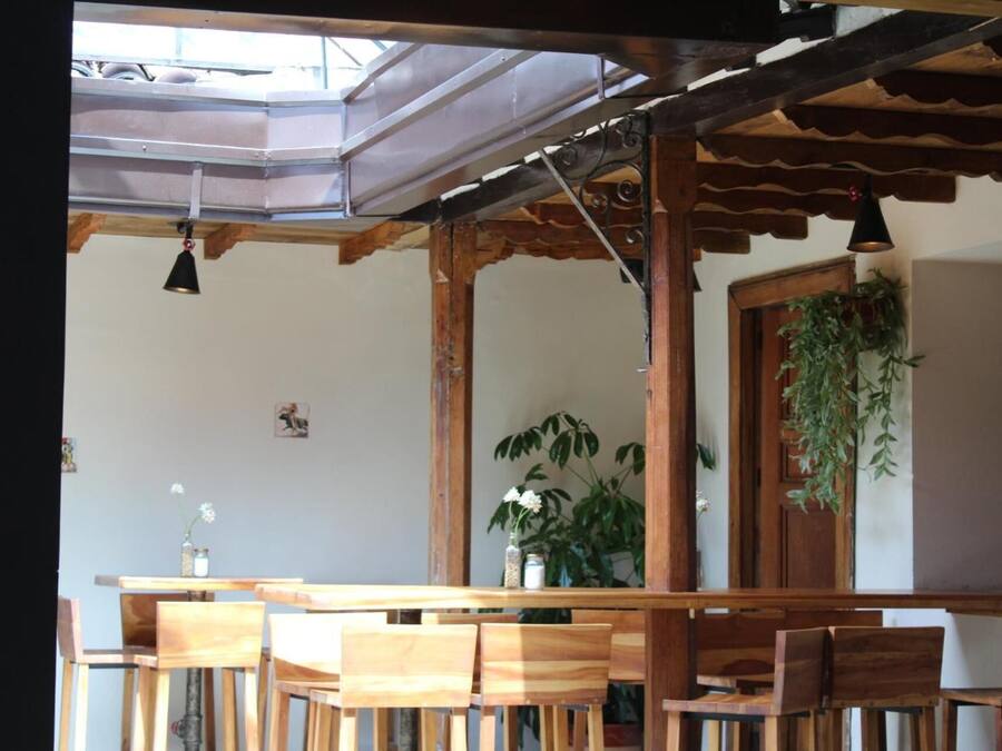 A wooden dining area with a high ceiling and a skylight.