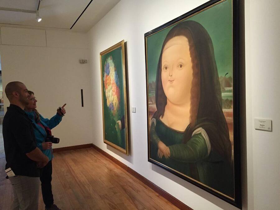 An art gallery with two large paintings on the wall.