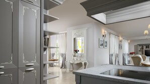 A modern kitchen with a central island, built-in cabinets, and a dining area with a table and chairs. - Villa Luna (Tar-Vabriga)