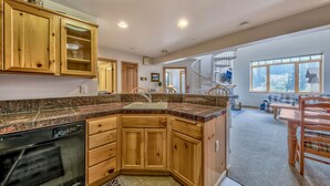A kitchen with wooden cabinets, granite countertops, and a dishwasher. - Luxury 2br + Loft, Lodge At Kirkwood Unbeatable Location 2 Bedroom Condo by RedAwning (Kirkwood)