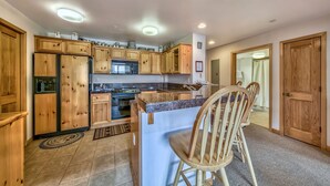 A kitchen with wooden cabinets, a microwave, an oven, and a sink. - Luxury 2br + Loft, Lodge At Kirkwood Unbeatable Location 2 Bedroom Condo by RedAwning (Kirkwood)