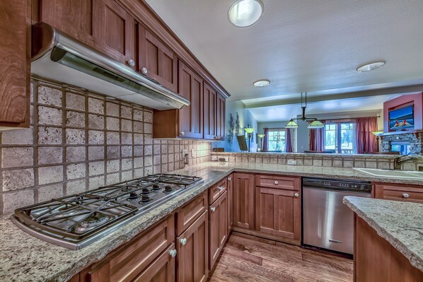 A kitchen with wooden cabinets, a stainless steel stove, and a dishwasher.