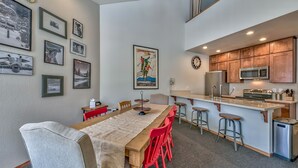 Een moderne keuken met houten kastjes, een roestvrijstalen koelkast en een magnetron.