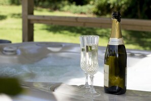 A bottle of Prosecco and a glass on a table outdoors.
