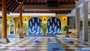 A checkered floor with yoga mats and towels, a pool, and decorative wall panels. - Olcote in Ceylon (Piliyandala)