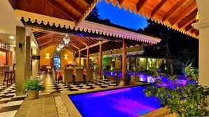 A pool area with a checkered floor, a covered seating area, and a bar. - Olcote in Ceylon (Piliyandala)