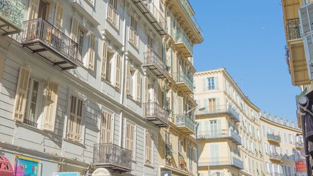 A row of multi-story buildings with balconies, a clear blue sky, and a sign for "Institut". - SunlightProperties LEGEND: 2 Bedroom Rental, near Beach with balcony & AC (Nice)