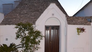 A small building with a dark brown door, white walls, and a tiled roof. - Trulli Casa Alberobello (Alberobello)