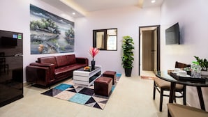 A modern living room with a red sofa, a coffee table, and a painting on the wall. - Aparthanoi (Hanoi)
