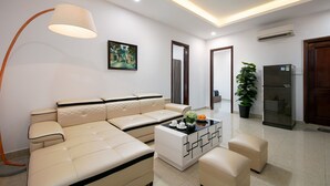 A modern living room with a sofa, coffee table, and a floor lamp. - Aparthanoi (Hanoi)