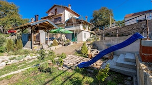 A two-story house with a patio area, a barbecue grill, and a blue slide. - Gorgeous home in Vele Mune (Vele Mune)