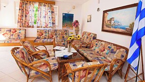 A living room with wicker furniture, a coffee table, and a flag. - Sunrise Apartments Hersonissos (Hersonissos)