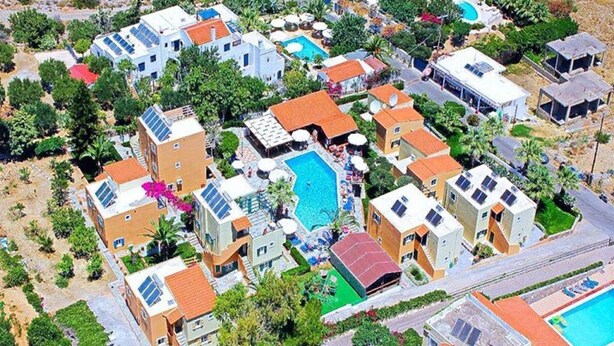 A residential area with multiple houses, a swimming pool, and solar panels. - Sunrise Apartments Hersonissos (Hersonissos)