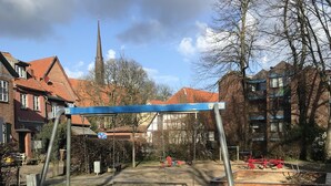 A playground with swings and a sandbox.