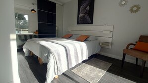 Une chambre moderne avec un grand lit, une chaise, un bureau et une fenêtre.