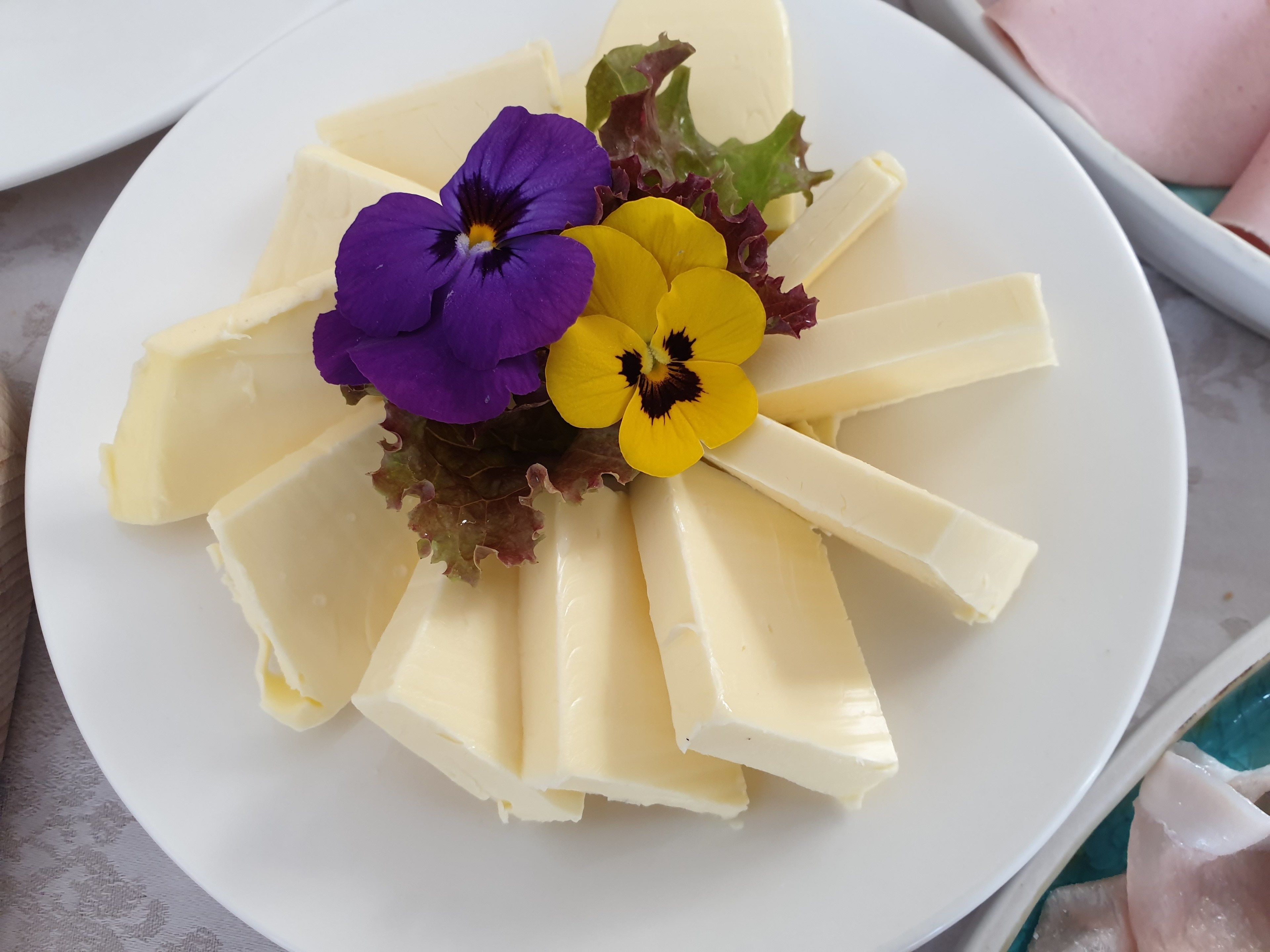 Ein Käseplatte mit Blumen.