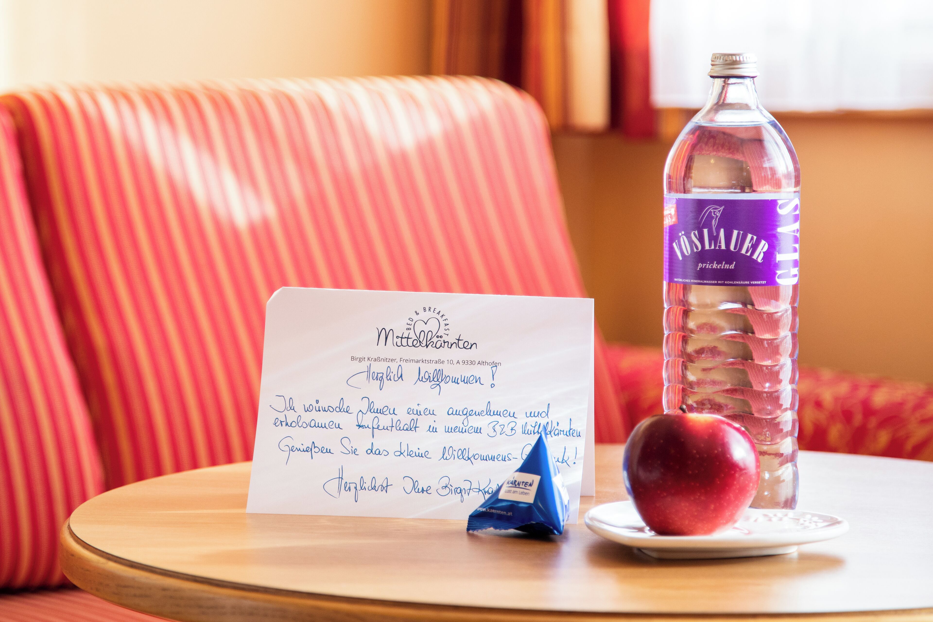 A table with a bottle of water, an apple, and a handwritten note.