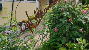 A two-story building with a sign reading "Mittelkanchen" and a decorative metal sign in the foreground. - Bed & Breakfast Mittelkärnten (Althofen)